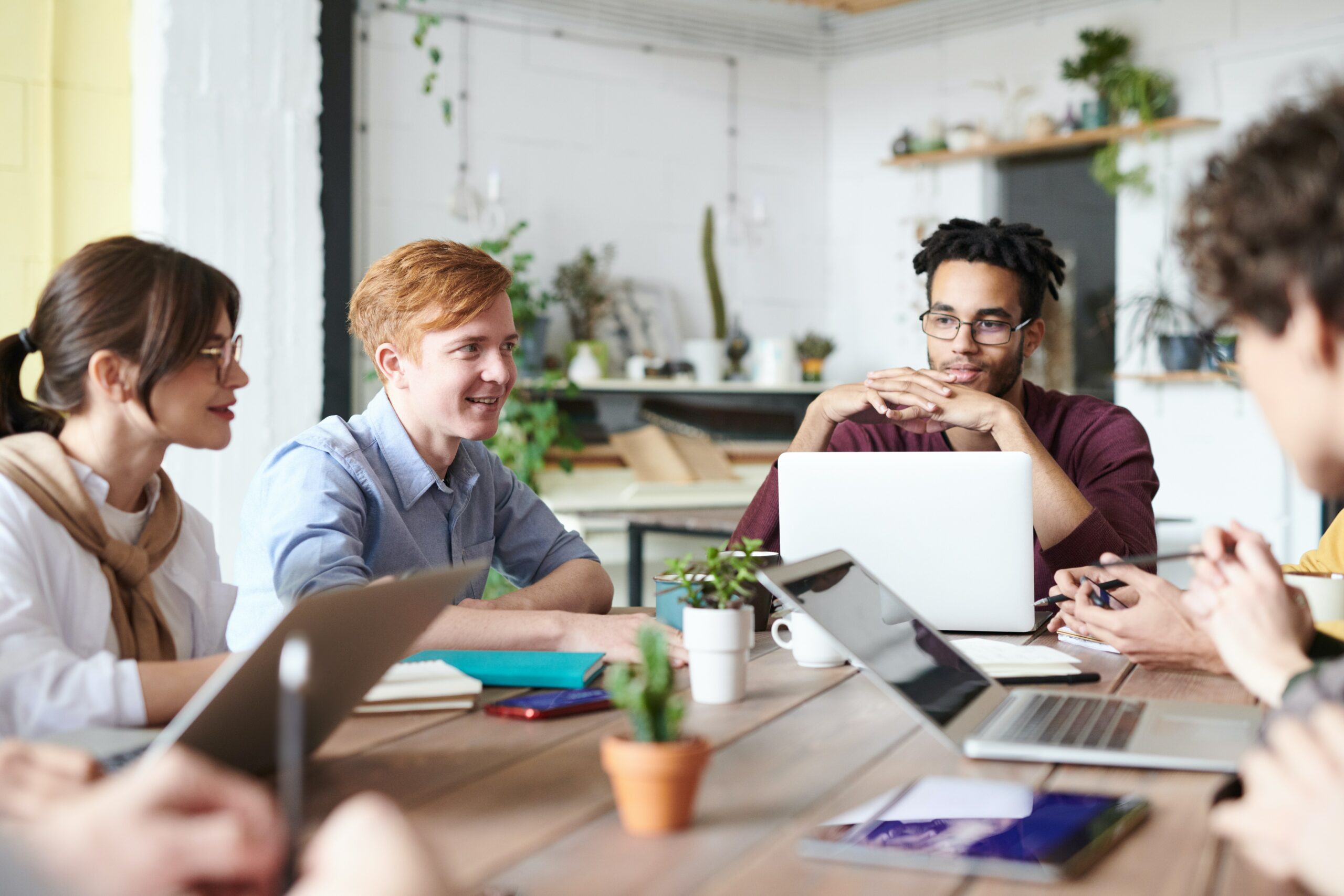 Digitale Zusammenarbeit am Besprechungstisch im Team mit Frauen und Männern